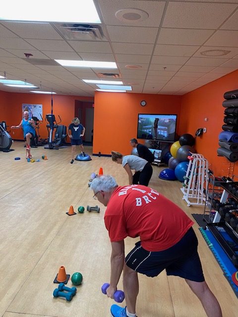 A person exercising on a mat in a group class