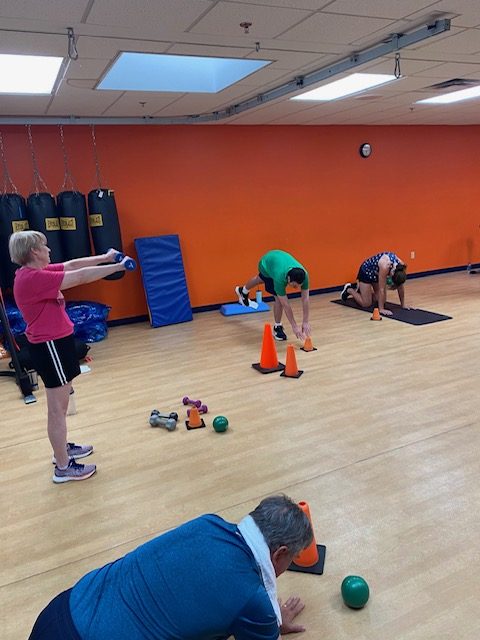 A supportive group fitness class at The Fitness Initiative